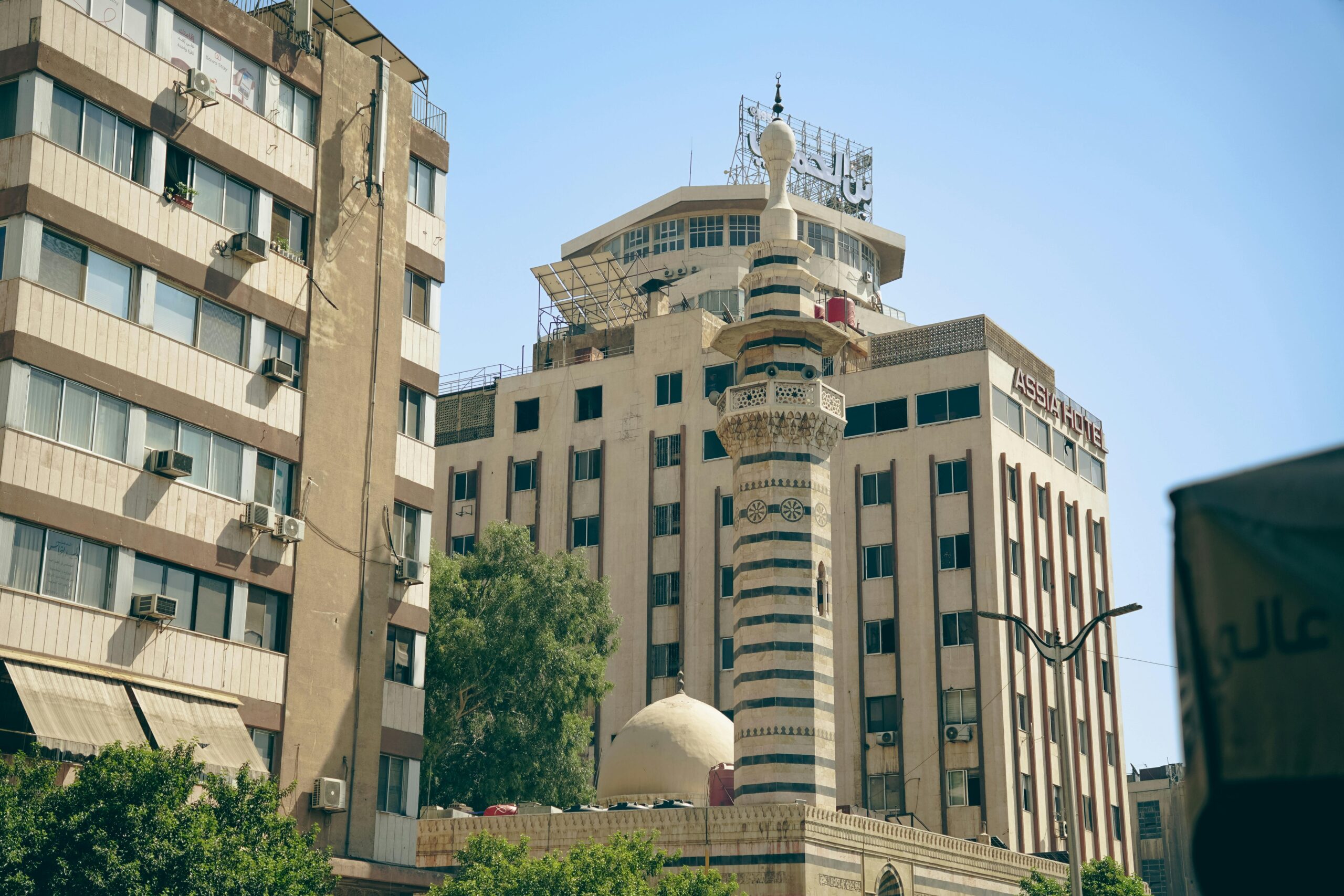 A blend of modern and historic architecture featuring a mosque minaret in Damascus.